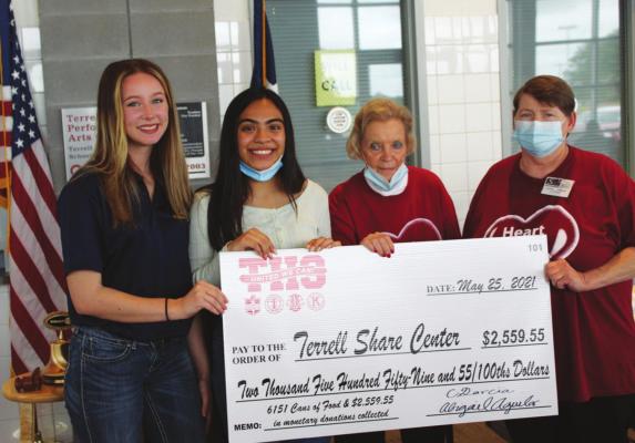 From left, Terrell High students Rylee Riggin and Abigail Aguilar present Betty Glaeser, executive director of the Share Center, and Lynn Meador of the Share Center with a ceremonial check for $2,559 in cash and 6,151 cans of food. HANK MURPHY PHOTO