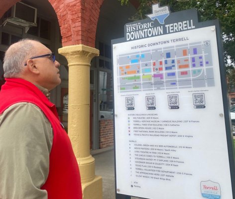 Mayor Rick Carmona takes a look at one of the new downtown signs. The signs include QR codes that provide links to pages that are updated by the Terrell Chamber of Commerce to assist visitors with local up-to-date tourist information. Courtesy photo