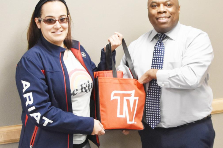 Elika Salazar is seen with Terrell Health Science Center Counselor Jeffrey Ballom as she is presented with a gift bag she won during early registration for the spring semester. Courtesy photo