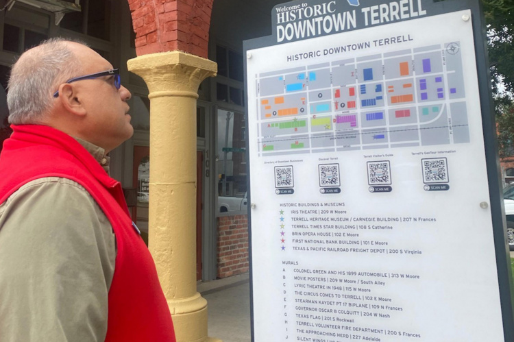 Mayor Rick Carmona takes a look at one of the new downtown signs. The signs include QR codes that provide links to pages that are updated by the Terrell Chamber of Commerce to assist visitors with local up-to-date tourist information. Courtesy photo