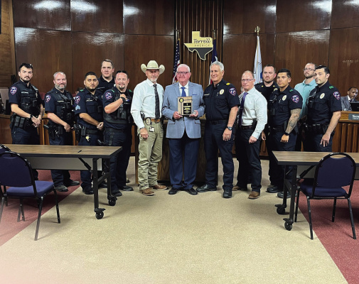Terrell Police Chaplain Gary Weems (middle) is honored during the Aug. 15 Terrell City Council meeting for his decades of service to the police department and the community alongside Police Chief Ken McKeown (right) and officers from the department. Photo courtesy of Bodey Cooper