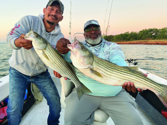 Guide Dave Escamilla with Striper Express and Damien Antoine from Baton Rouge show off a couple of many nice stripers landed last week at Lake Texoma. Photo by Luke Clayton