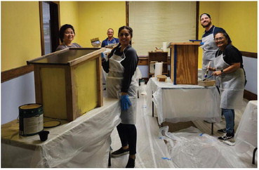 The Baylor Scott and White team helps paint boxes that will hold books for donation and pickup as part of Kaufman County Community United's Lending Libraries program. Photo courtesy of Kaufman County Community United