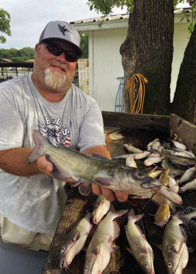 Cedar Creek Lake guide Jason Barber with a good ‘mess’ of channel catfish he and Luke landed using cane poles and fishing off the bank. Photo by Luke Clayton