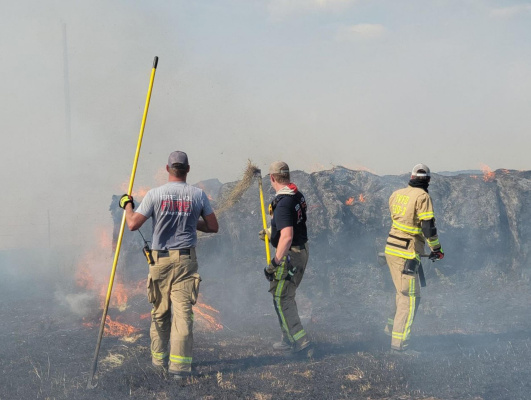 Members of the Terrell Fire Department and Terrell Volunteer Fire Department worked to contain a large grass and hay fire in the areas of Poetry and Town North Aug. 1. The blaze would ultimately consume more than 100 round bales. Photo courtesy of the TVFD Facebook page