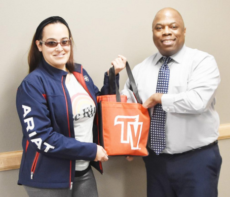 Elika Salazar is seen with Terrell Health Science Center Counselor Jeffrey Ballom as she is presented with a gift bag she won during early registration for the spring semester. Courtesy photo