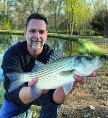 Brenton Kernes with Newalla Fish Company with a nice hybrid striper stocked as a fry and later caught in a small backyard pond. Photo courtesy Brenton Kernes