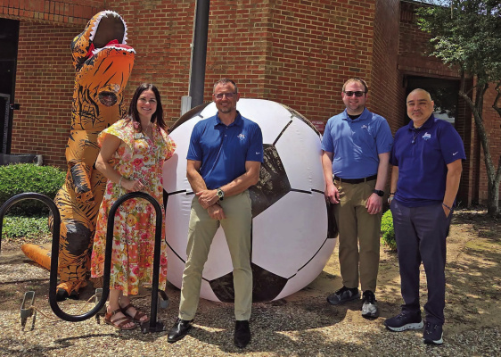 The Kaufman County Comunidad Unida soccer ball made its way to the Riter C. Hulsey Public Library in commemoration of the 2026 FIFA World Cup on Wednesday, June 24. Joining HPL Library Director Rebecca House is (from left) City of Terrell IT Director Damon Holzer, Finance Director Matt Poston and Senior Accountant Juan Flores. Apparently even Sir Rexington has soccer fever. Photo courtesy of City of Terrell