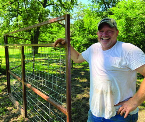 Steven Waugh setting up a hog trap in Luke’s neighbor’s yard. The flooded bottomland has pushed wild porkers to higher ground in search for food. Photo by Luke Clayton