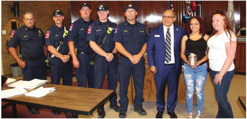 From left are Fire Chief Shane LeCroy, firefighter/paramedic Tanner Smith, driver/engineer Joey Bush, firefighter/paramedic Konner Marshall, Capt. Michael Angell, Mayor Rick Carmona, Jaliyah Mims, and her mother, Hannah Rickman. HANK MURPHY PHOTO