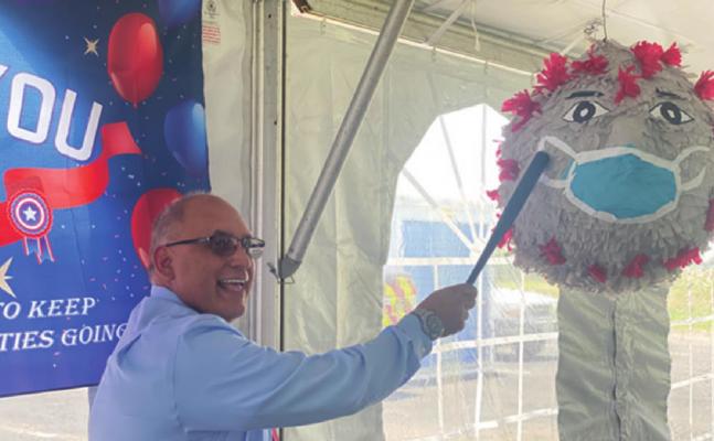 Terrell Mayor Rick Carmona takes a whack at a coronavirus piñata during an appreciation event for those who operated and staffed the county’s vaccination hub at TVCC.COURTESY PHOTO