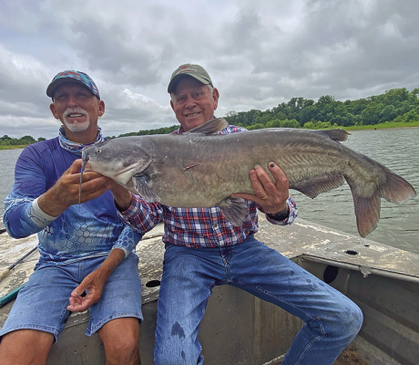 Guide J.C. McCullough (left) and Luke with a big blue catfish last week from the Red River below Lake Texoma. Photo by Jeff Rice