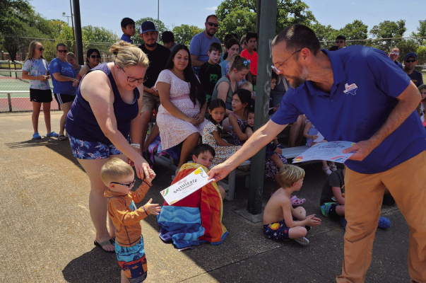 Children enjoy the award presentation honoring their achievements during the end of summer reading program pool party at Terrell at Riter C. Hulsey Public Library as Terrell City Manager Mike Sims hands out awards. Additional photos on 2A. Photo courtesy of Riter C. Hulsey Public Library Facebook page