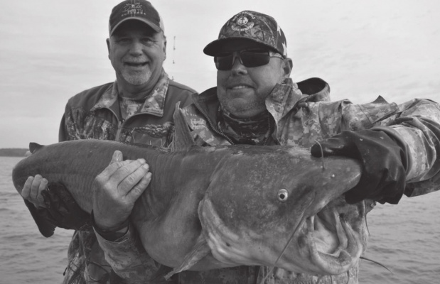 Jeff Rice, left, and catfish guide Tony Pennebaker show off a big blue catfish Jeff landed last week. PHOTO BY LUKE CLAYTON