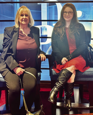 Denise York (left) and Catie Burgess pose in one of the mock-ups to simulate being on stage at the Dr. Phil show. Courtesy photo