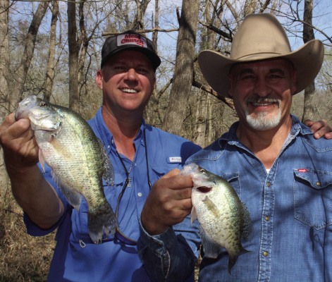 Guide Chris Webb, left, and Kenneth Shepherd show off some nice crappie landed from a backwoods creek recently. Spawning crappie have moved into the creeks above reservoirs and catching should remain good for a few more weeks. Photo by Luke Clayton
