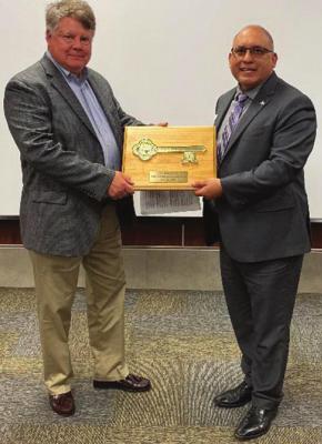 Bill Huthmacher, left, gets the key to the city from Terrell Mayor Rick Carmona after Huthmacher claimed his auction prize and became Mayor for the Day. COURTESY PHOTO