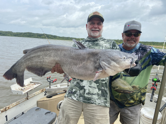 Jeff Rice, left, and Lake Tawakoni catfish guide Tony Pennebaker show off a giant blue catfish landed from shallow water last week. Photo by Luke Clayton
