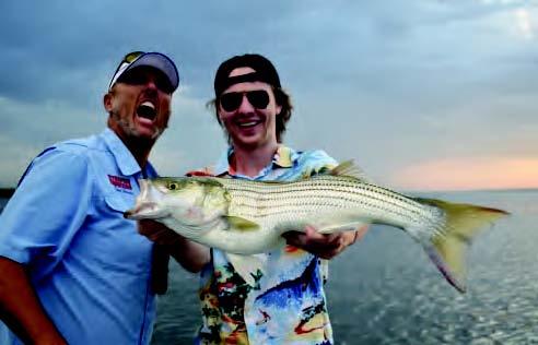Guide Chris Carey and Luke Zimmerman having a big time showing off one of many hard fi ghting stripers landed earlier this week.