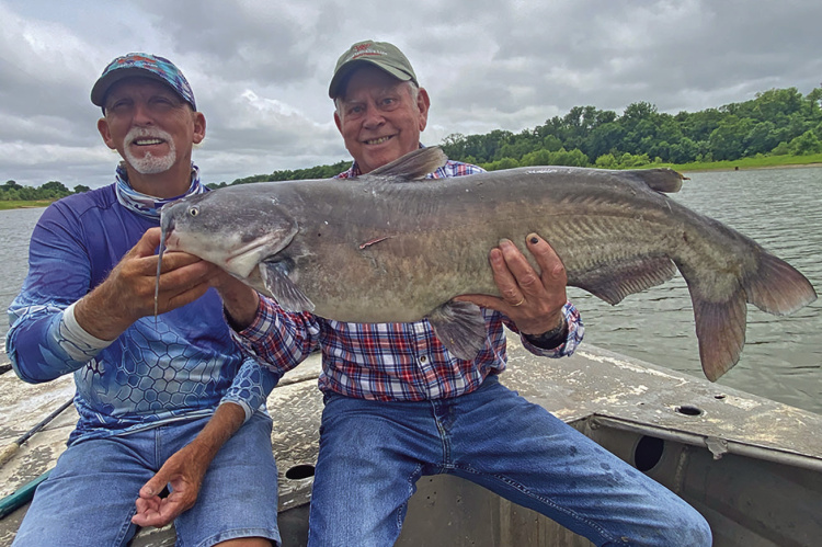 Guide J.C. McCullough (left) and Luke with a big blue catfish last week from the Red River below Lake Texoma. Photo by Jeff Rice