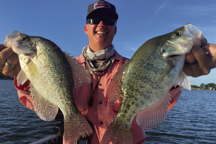 Cedar Creek Lake guide Chris Webb with two of many crappie landed this past week. Crappie are on a very dependable summer bite, holding tight to submerged structure but the bite is soft and proper technique is key to getting the hook set. Photo by Luke Clayton