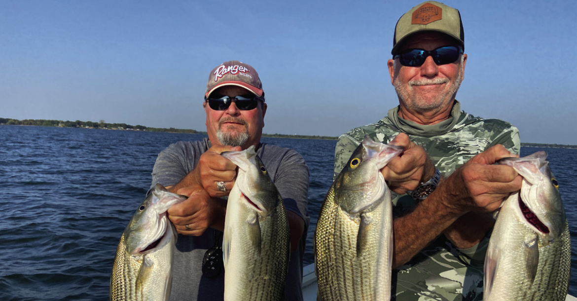 Guide Tony Parker (lt) and Jeff Rice show off a few nice fish landed during the first few hours of daylight last week. The bite was very good for hybrid stripers, an occasional pure striper and some jumbo white bass. Photo courtesy of Luke Clayton